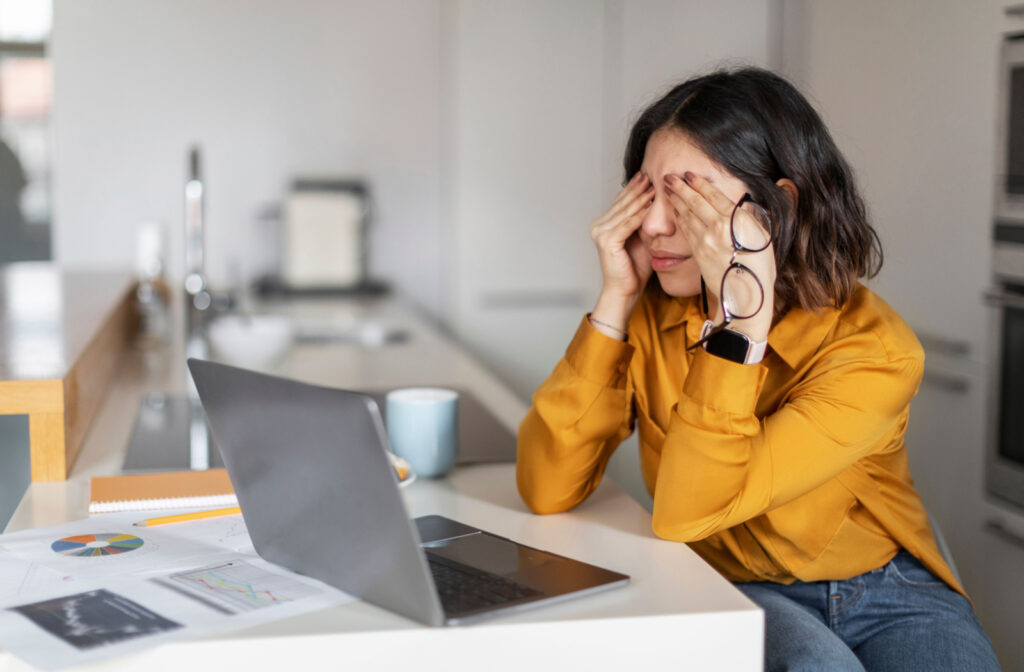 A woman suffering from eye strain after working on her laptop.